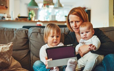 woman with 2 children looking at ipad together