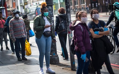 people wearing face masks at bus stop 